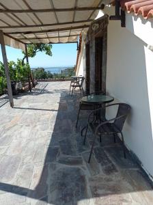 a patio with a table and chairs on a stone floor at Christos center rooms in Raches +5 photos