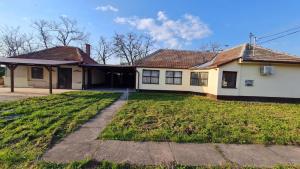 une maison avec une cour d'herbe devant elle dans l'établissement Sarudi vendégház, à Sarud