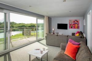 a living room with a couch and a table at PointBreak Sleeps 12 with hot tub-Great celebration house-Dog friendly in Padstow