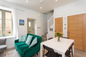 a living room with a green chair and a table at Beautiful Honeycomb Cottage in heart of Cotswolds in Chipping Norton