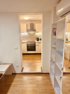 a kitchen with white cabinets and a hard wood floor at Blue Sun in Ljubljana