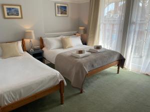 ein Hotelzimmer mit 2 Betten und einem Fenster in der Unterkunft The Limes in Swanage