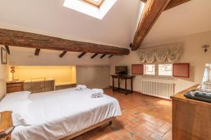 1 dormitorio con 1 cama blanca grande y escritorio en Casa Isolani - Santo Stefano, en Bolonia