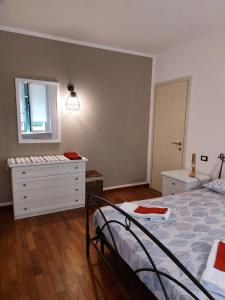 a bedroom with a bed and a dresser and a mirror at La casa di Max in La Spezia