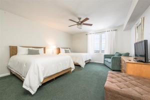 1 dormitorio con 2 camas, TV y sofá en Unit 2432 Ocean Walk - 2 Bedroom Ocean View en Daytona Beach