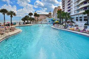 a swimming pool at a resort with people sitting in chairs at Unit 2432 Ocean Walk - 2 Bedroom Ocean View in Daytona Beach