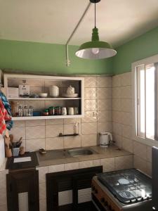 a kitchen with a sink and a green wall at Appart F2 plein centre in Klétigan