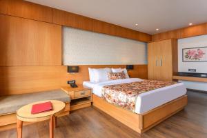 1 dormitorio con cama, escritorio y mesa en Summit Montana Suites & Spa, en Darjeeling