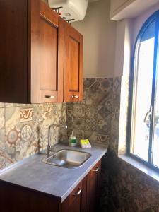 a kitchen with a sink and a window at Taormina Center Private Apartments By Fragranza Di Sicilia in Taormina