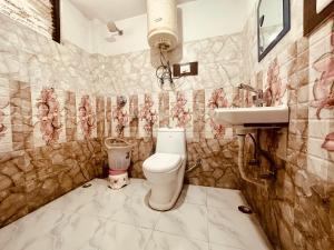 a bathroom with a toilet and a sink at WooibHotels The Solitaire in Manāli