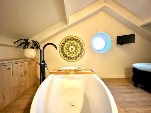 a bath tub in a room with a ceiling at B&B Logement 't Slikje in Groede