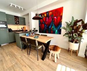 a kitchen and dining room with a table and a painting at Logement 't Slikje Groede in Groede
