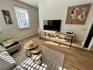 a living room with a couch and a tv at B&B Logement 't Slikje in Groede