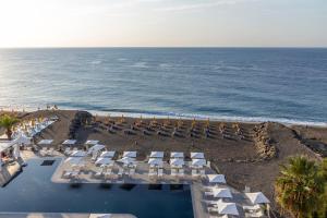 an aerial view of a beach with chairs and the ocean at Delta Hotels by Marriott Giardini Naxos in Giardini Naxos