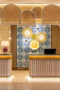 a lobby with a counter and a patterned wall at Delta Hotels by Marriott Giardini Naxos in Giardini Naxos