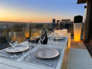 a table with plates and wine glasses on a balcony at Penthouse Apartment in the Heart of London in London