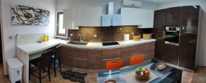 a kitchen with white cabinets and a counter with orange chairs at Lemnos Luxury Apartment in Mirina +17 photos