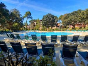 a group of chairs in front of a swimming pool at Appartement Golf et Océan in Moliets-et-Maa