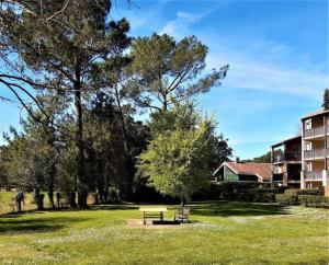 a park with a bench in front of a building at Appartement Golf et Océan in Moliets-et-Maa