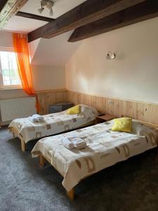 a room with three beds in a room at Folwark Tumiany Pokoje & Restauracja in Tumiany