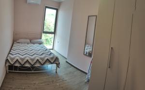 a small bedroom with a bed and a window at Lemnos Luxury Apartment in Mirina
