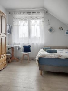 ヤスタルニャにあるPokoje u Rybakaのベッドルーム1室(ベッド1台、デスク、窓付)