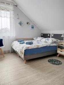 - une chambre avec un lit et une couette bleue dans l'établissement Pokoje u Rybaka, à Jastarnia