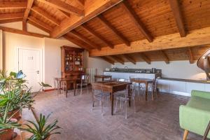 comedor con techos de madera, mesas y sillas de madera en Casa Isolani - Santo Stefano, en Bolonia