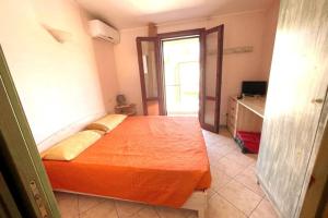 a bedroom with a bed with an orange sheet at Casa Teria in Villasimius