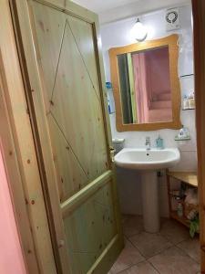 a bathroom with a sink and a shower with a mirror at Casa Teria in Villasimius