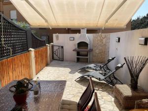 a patio with a fireplace and a table with at Casa Teria in Villasimius