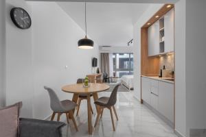 塞薩羅尼基的住宿－ΙΩΚΑ Suites / the Urbitality Project，厨房以及带桌椅的用餐室。