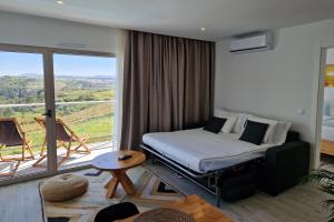 a hotel room with a bed and a large window at Ericeira Surf Apartments in Ericeira