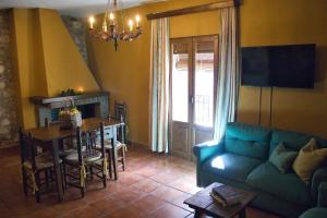 a living room with a blue couch and a table at Casa Rural Las Martas in Acebo