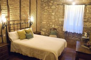 1 dormitorio con cama y pared de ladrillo en Casa Rural Las Martas, en Acebo