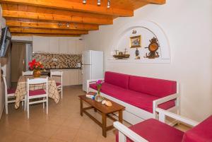 a living room with a red couch and a kitchen at Two little houses with panorama view in Kýthira