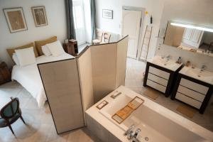 a bathroom with a bed and a tub and a bedroom at Maison Harmonie in La Châtre