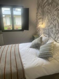a bed in a bedroom with a window at Nid douillet in Pont-Audemer