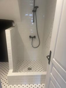 uma casa de banho com chuveiro e piso em preto e branco em Nid douillet em Pont-Audemer