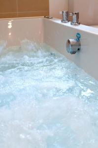 a bath tub filled with lots of water at PointBreak Sleeps 12 with hot tub-Great celebration house-Dog friendly in Padstow