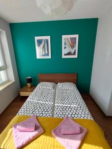 a bedroom with a bed with two pink towels on it at Cicha Przystań - Apartament Wyspa Solna in Kołobrzeg