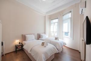 2 Betten in einem weißen Zimmer mit einem Flachbild-TV in der Unterkunft #Fandango Gorgeous Neoclassical Apartment in Thessaloniki