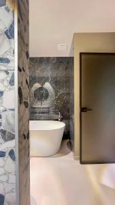 a bathroom with a bath tub and a stone wall at Auberge Pom'Poire in Azay-le-Rideau