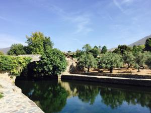 un puente sobre un río con árboles en el fondo en Casa Rural Las Martas, en Acebo