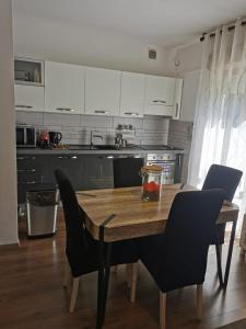 cocina con mesa de madera con 2 sillas y mesa en Grande appartamento in Centro, 4 posti letto, en Gorizia