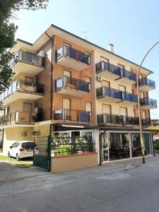 un gran edificio de apartamentos con balcones en una calle en Lido, en Lido delle Nazioni