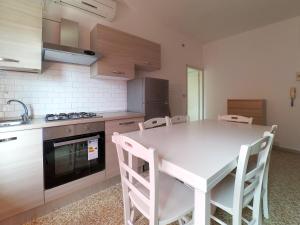 una cocina con mesa blanca y sillas. en Lido, en Lido delle Nazioni