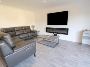 a living room with a couch and a flat screen tv at Kerry Cottage in Holywell
