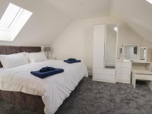 ein Schlafzimmer mit einem Bett mit zwei blauen Handtüchern darauf in der Unterkunft Kerry Cottage in Holywell