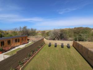 Blick auf einen Garten mit Stühlen und ein Gebäude in der Unterkunft Kerry Cottage in Holywell